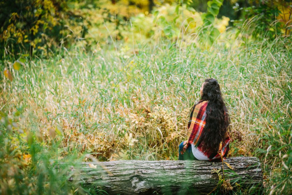 Woman sitting on log in nature