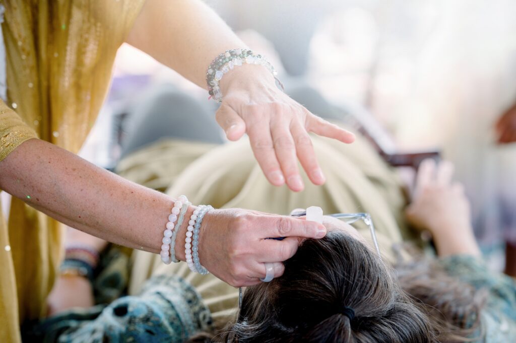 Healer giving a client reiki with crystals