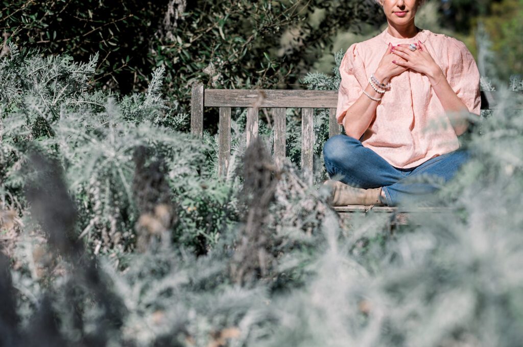 Woman in garden with hands over her heart