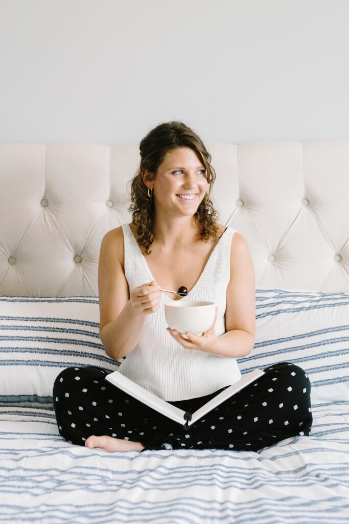 Happy woman on bed with tea and journal