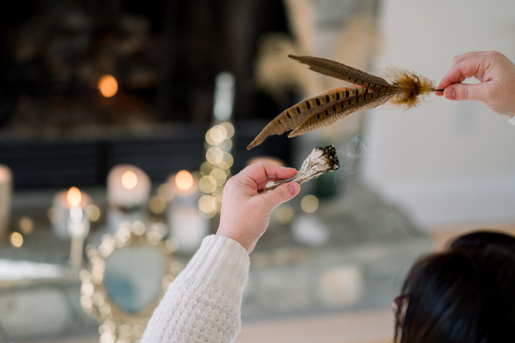 A person holding burning sage